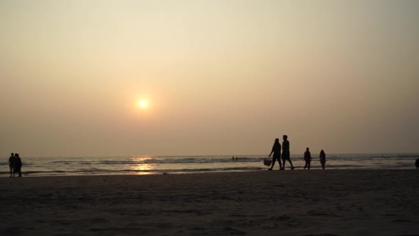 La gente camina en la playa al atardecer. El concepto de un carril a lo largo del mar o el océano . — Vídeos de Stock