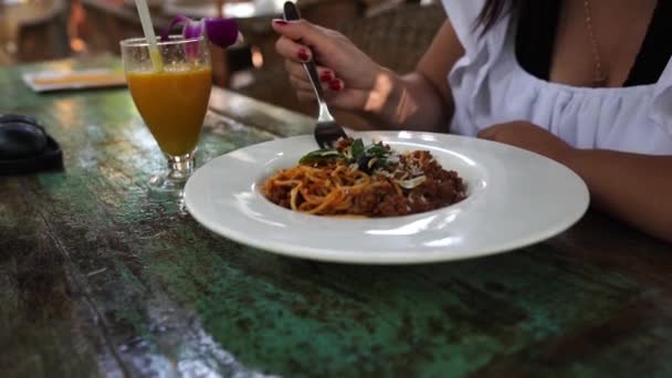 Une jeune femme cueille avec une fourchette dans un café tropical. — Video
