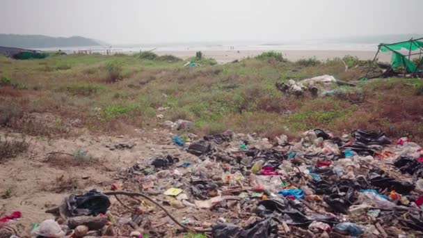 Uma pilha de lixo fica perto da costa do mar. O conceito de poluição ambiental . — Vídeo de Stock