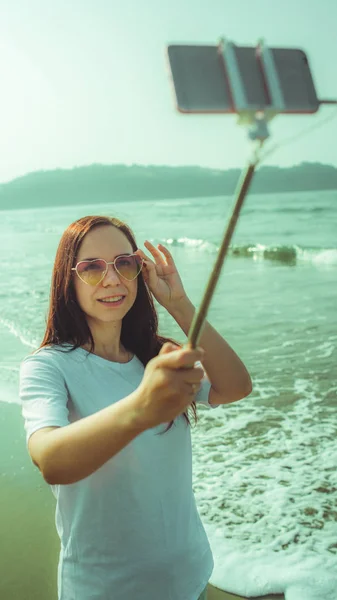 Happy female taking selfie near sea. From above glad woman using — ストック写真