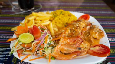 Restoran masasında nefis yemekler. Kafedeki süs masasının üzerine karides ve patates kızartması konmuş lezzetli bir tabak.