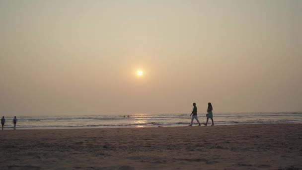 Sunset over sea and beach. Cloudless sundown sky over waving sea and sandy beach in evening on resort — Stock Video