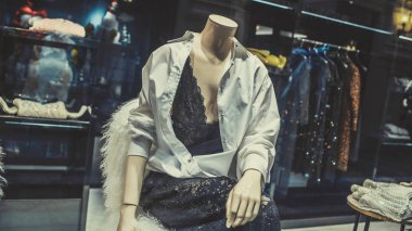 Bir giyim mağazasının vitrininde bir manken duruyor. Giyim mağazası konsepti - vitrindeki mankenler