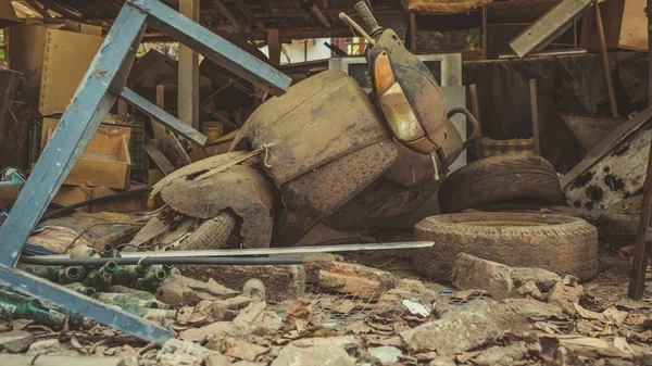 Un viejo scooter está tirado en un basurero. Un montón de basura vieja en el polvo y la suciedad . — Foto de Stock