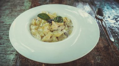 Kafe masasında nefis bir makarna. Lokantadaki masaya krema soslu lezzetli makarna ile yakın çekim tabağı.