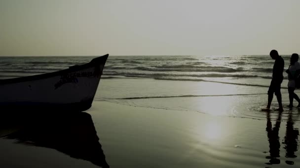 Índia, Goa, 15 de dezembro de 2019: Empty boat on sandy beach in bright day. Grande barco branco velho à beira-mar arenoso pronto para navegar em dia brilhante na praia — Vídeo de Stock