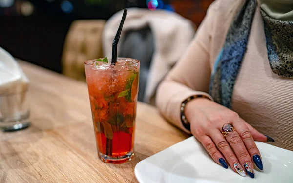 Eine Frau trinkt in einem Café einen alkoholischen Cocktail. Nahaufnahme einer Frau — Stockfoto