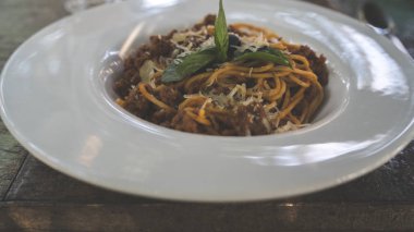 Kafe masasında nefis bir makarna. Bir porsiyon lezzetli makarna ve kıyma ile yakın plan bir restoranda masaya koyun