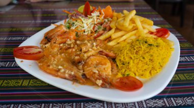 Restoran masasında nefis yemekler. Kafedeki süs masasının üzerine karides ve patates kızartması konmuş lezzetli bir tabak.