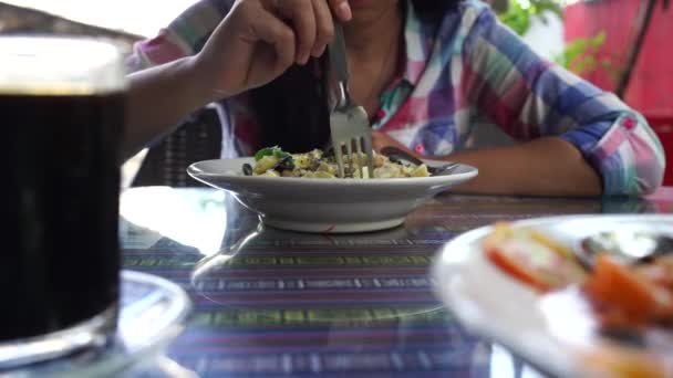 Massa gostosa na mesa de café. Close-up de uma mulher comendo uma porção de massa deliciosa com molho de creme em uma mesa em um restaurante — Vídeo de Stock