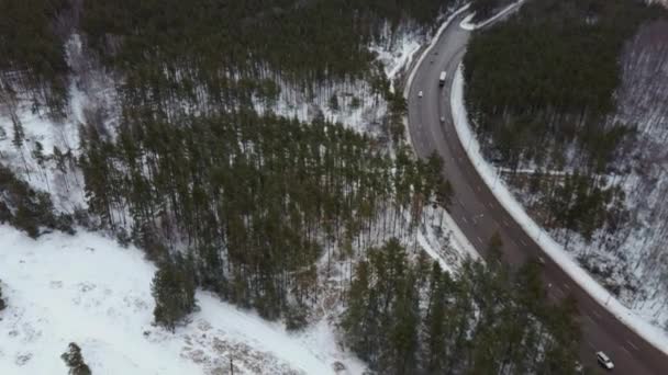 冬天的交通。冬季汽车行驶在道路上，积雪覆盖着树木，鸟瞰着天空. — 图库视频影像
