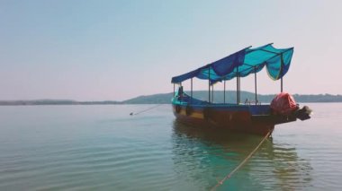 Denizde renkli bir turist teknesi. Güneşli bir günde bulutsuz mavi gökyüzüne karşı durgun deniz suyunda yüzen insanla parlak bir turist teknesi.
