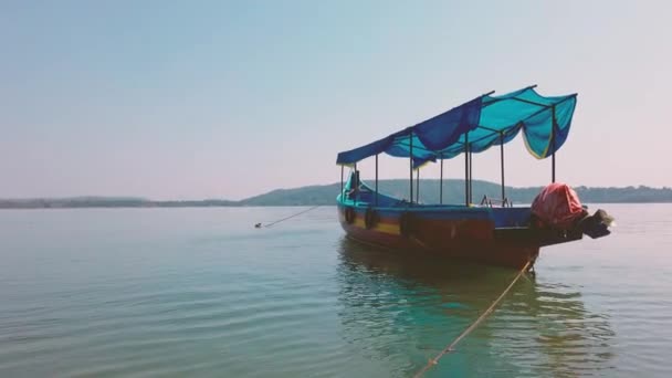 Denizde renkli bir turist teknesi. Güneşli bir günde bulutsuz mavi gökyüzüne karşı durgun deniz suyunda yüzen insanla parlak bir turist teknesi. — Stok video