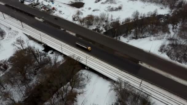 Trafiken en vinterdag. Bilar på väg på vintern med snötäckta träd flygfoto. — Stockvideo