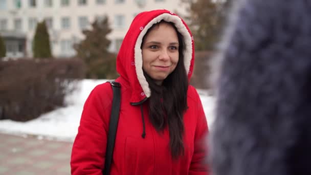 Dos mujeres hablando de pie en la calle en invierno. El concepto de diversión y diversión. — Vídeo de stock