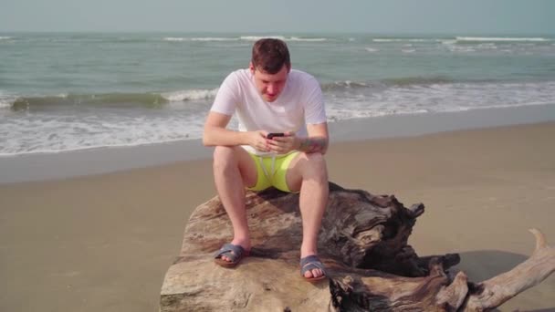 Молодий Чоловік Використовує Смартфон Пляжі — стокове відео