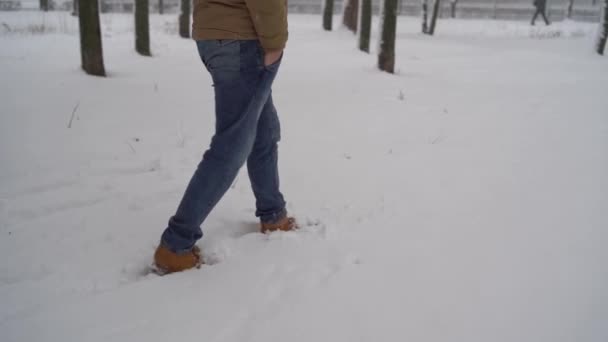 Een man loopt in de sneeuw, close-up. Winterwandelconcept — Stockvideo