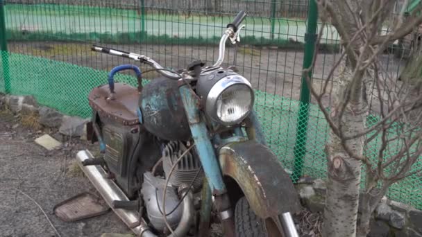 2019年1月25日，俄罗斯斯塔里 · 奥斯科勒（英语：Stary Oskol）：旧锈迹斑斑的摩托车靠近地面围栏。接近被遗弃的破摩托车. — 图库视频影像