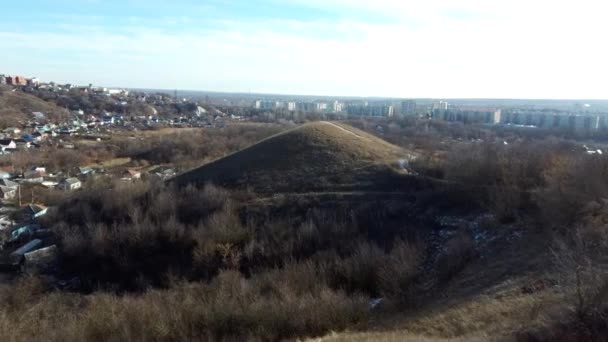 Flygfoto över krita berg på landsbygden på molnig dag. Fåglar syn på liten stad i fjärran. — Stockvideo