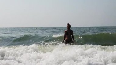 Siyah mayo giyen genç bir kadın zamanını denizde ya da okyanusta geçirir. Kız dalgalardan sığınıyor..