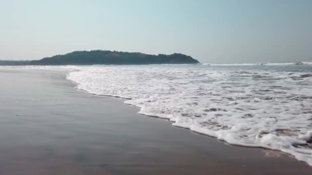 Onde di mare schiumose sulla riva. Onde schiumose di acqua di mare pulita rotolando sulla spiaggia di sabbia bagnata nella giornata di sole in resort — Video Stock