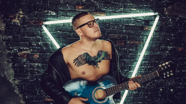 Stylový Chlap Ptačím Tetováním Hrudi Odvrací Pohled Hraje Kytaru Zatímco — Stock fotografie