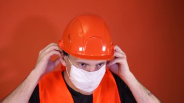 Sağlık maskeli ve tulumlu erkek inşaat işçisi.