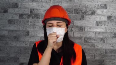Yetişkin kadın yüzünü maskeyle öksürerek kapattı. Koronavirüs salgını veya hastalıklar kavramı.