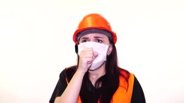 Tulumlu ve maskeli beyaz arka planda öksüren kadın inşaat işçisi. Enfeksiyon tehdidi kavramı.