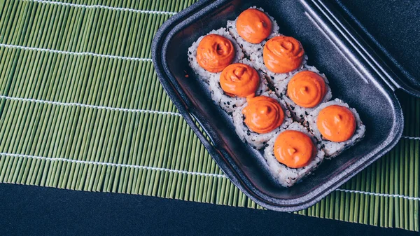 Los rollos de sushi se mezclan en un recipiente de plástico, un conjunto de deliciosos rollos de sushi. Comida japonesa. Menú de sushi. Los rollos de sushi se mezclan en un recipiente de plástico —  Fotos de Stock