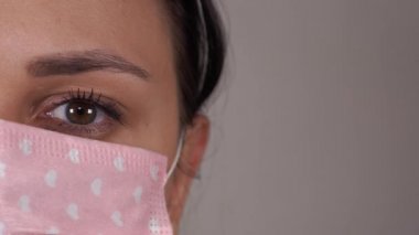 Yüzünde tıbbi maske olan bir kadın. Koronavirüs salgını veya hastalıklar kavramı.