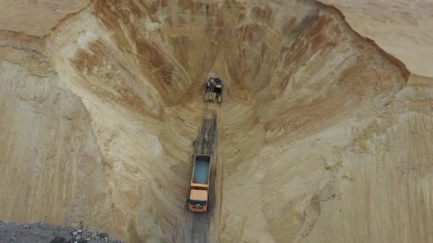 El camión de basura va a ser cargado. La vista desde la altura del vuelo del pájaro para cargar arena en el camión. El pozo de arena tiene maquinaria pesada: una excavadora y un camión . — Vídeos de Stock