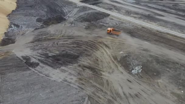 Il camion della discarica sta arrivando. Un camion scarico in una cava. Dumper in corso, passando sopra il lato della costruzione dell'autostrada. Vista aerea . — Video Stock