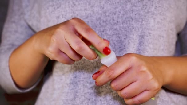 Mujer elimina esmalte de uñas rojo con removedor de esmalte de uñas. La señora quita el esmalte de uñas. Esmalte de uñas rojo con almohadilla de algodón blanco. — Vídeos de Stock