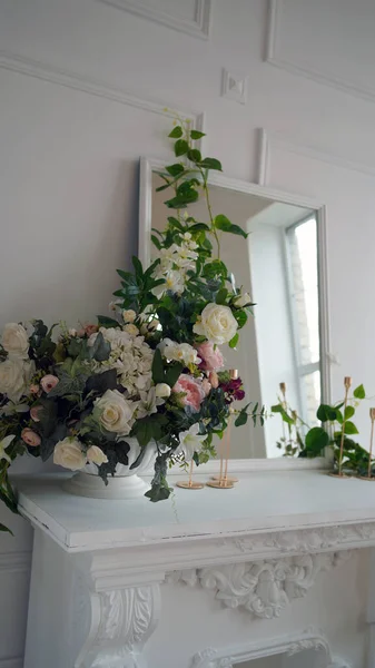 Avvicinamento di interno di uno di angoli di camera. Grande specchio con fiori decorativi e candele su tavolo bianco . — Foto Stock