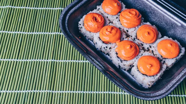 I panini di sushi si mescolano in un contenitore di plastica, insieme di deliziosi involtini di sushi. Cibo giapponese. Menù di sushi. involtini di sushi mescolare in un contenitore di plastica — Foto Stock