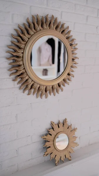 Närbild av speglar på vit tegelvägg. Vacker stor och liten spegel med dekorativ ram. — Stockfoto