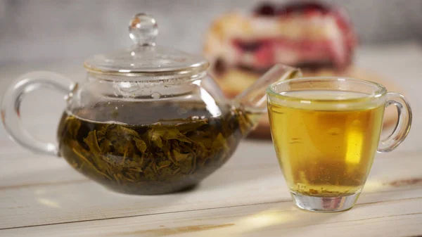Primer plano de té verde en tetera y taza en mesa de madera blanca . — Foto de Stock