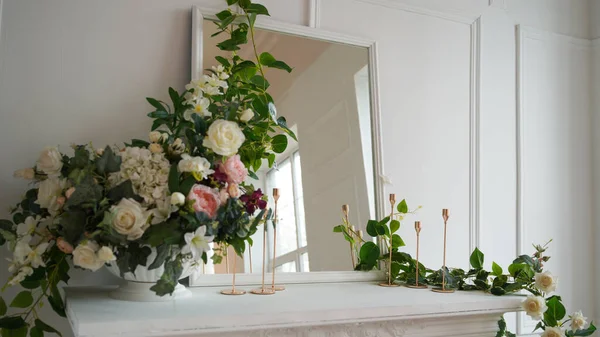 Avvicinamento di interno di uno di angoli di camera. Grande specchio con fiori decorativi e candele su tavolo bianco . — Foto Stock