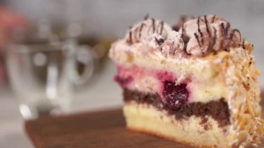 Tahtadaki kekin bir parçasını çaydanlıkta yeşil çay ve beyaz ahşap masada fincan ile kapat..