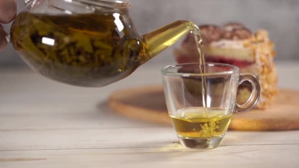 Close-up de chá verde em bule e xícara na mesa de madeira branca . — Vídeo de Stock