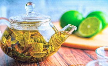 Çay yaprakları kaynayan suda demlenir ve küçük bir çaydanlığa karışır. Çay partisi konsepti. Çaydanlıkta yeşil çay
