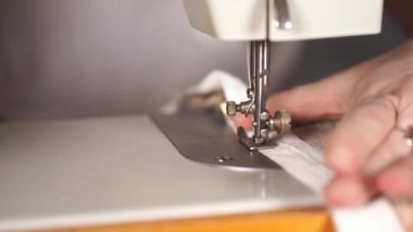 Kadın eli masanın üzerinde dikiş makinesini kapayın. Dikiş makinesi kullanan kadın perdesi..