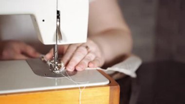 Kadın eli masanın üzerinde dikiş makinesini kapayın. Dikiş makinesi kullanan kadın perdesi..