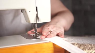 Kadın eli masanın üzerinde dikiş makinesini kapayın. Dikiş makinesi kullanan kadın perdesi..