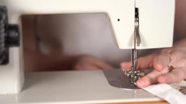 Kadın eli masanın üzerinde dikiş makinesini kapayın. Dikiş makinesi kullanan kadın perdesi..