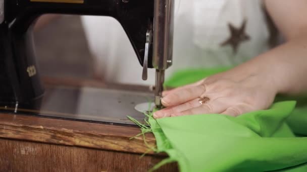 Großaufnahme einer alten Nähmaschine mit Frauenhänden auf dem Tisch. Frau näht Stoff mit sowjetischer Nähmaschine. — Stockvideo