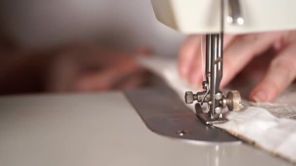 Primer plano de la máquina de coser con las manos de las mujeres en la mesa. Cortina de costura de mujer, usando máquina de coser . — Vídeo de stock