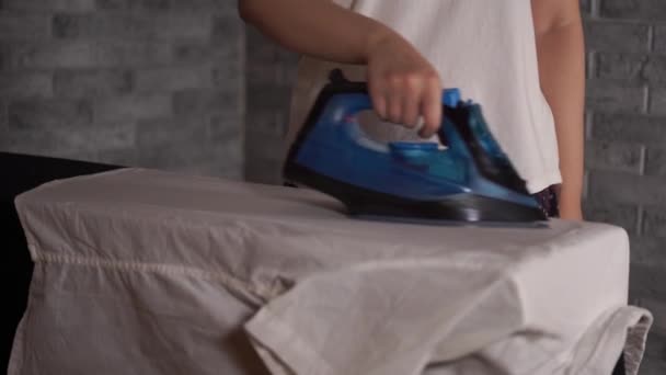 Γυναίκα σιδέρωμα ρούχα στην σιδερώστρα, κοντινό πλάνο — Αρχείο Βίντεο
