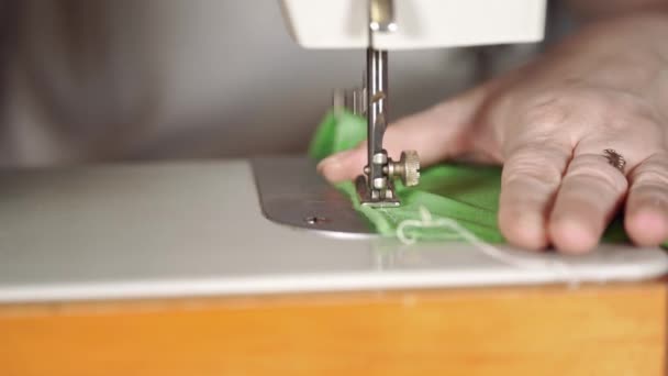 Крупним планом швейна машина з жіночими руками на столі. Жінка вишиває завісу, використовуючи швейну машинку . — стокове відео